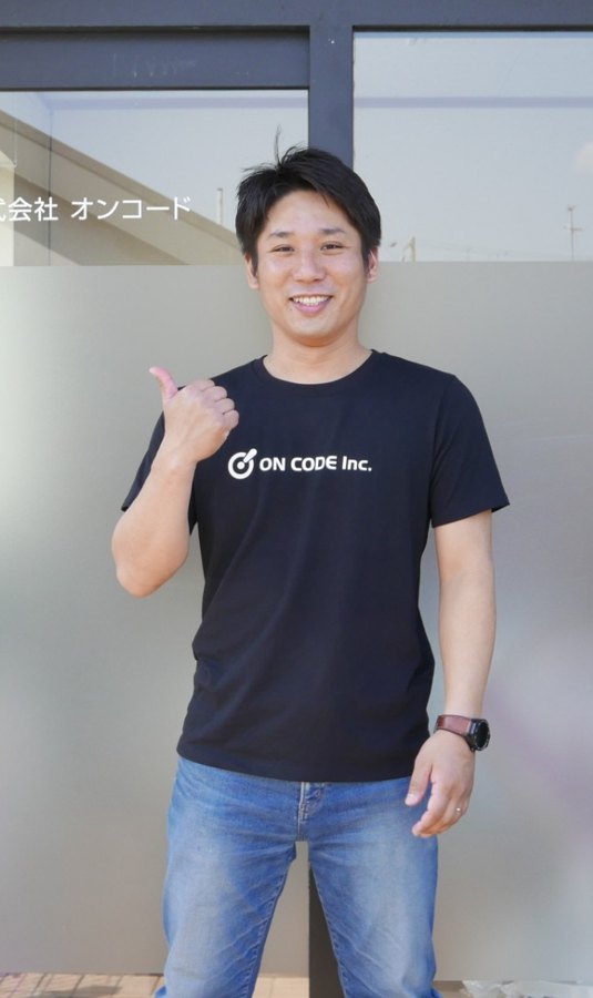 本社の前に立つ代表の髙木