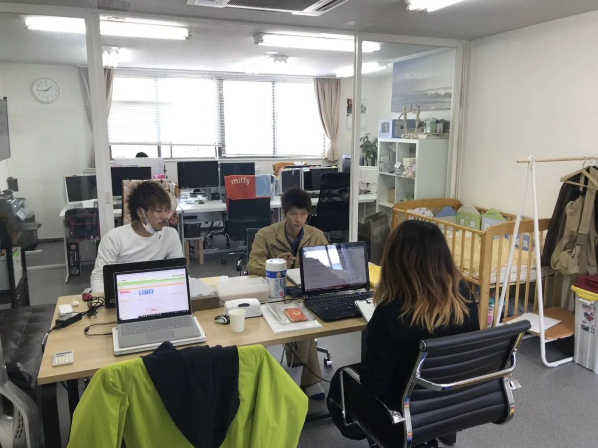 事務所で相談の写真を見て見積りをつくるスタッフ